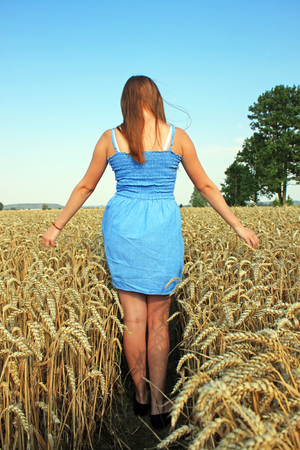 Beauty Girl Outdoors enjoying nature. Beautiful Teenage Model girl in white dress running on the Fieldの写真素材