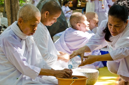 NONTHABURI THAILAND-APRIL13:people celebrate Songkran (new year / water festival: 13 April) by pouring water to nun and asked for blessings on Songkran festival in temple,Nonthaburi,Thailandのeditorial素材