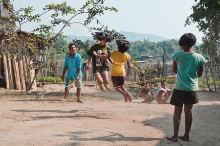 KANCHANABURI THAILAND-January 29:  An unidentified children playing Kra Dod Cheark (the rope jumping one of the favorite games for Thai children  )   on January 29, 2012  at KANCHANABURI THAILAND.のeditorial素材
