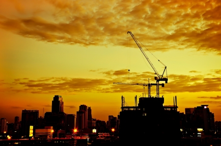 Industrial construction cranes and city silhouette over  sunrise のeditorial素材
