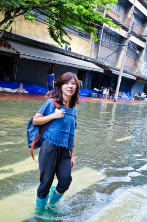 BANGKOK, THAILAND - OCT 31: Unidentified woman walks through flood waters  at Bangkokのeditorial素材