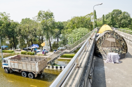 NAKHON PATHOM, THAILAND - NOV 15: Flood victim  become homeless, sleeps on the overpass at Phutthamonthon Sai 4 road  during the worst flooding crisis  on November  15, 2011 in Nakhon Pathom, Thailandのeditorial素材