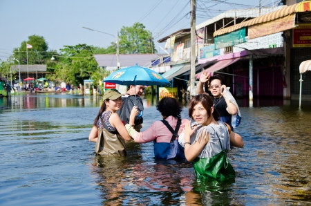 NAKHON PATHOM, THAILAND - NOV 15:  Unidentified people walk through flood water  at Phutthamonthon Sai 4 road  during the worst flooding crisis  on November  15, 2011 in Nakhon Pathom, Thailandのeditorial素材