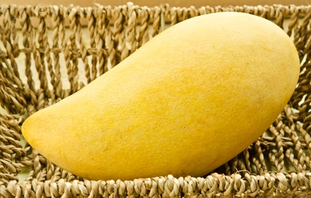 Fresh golden mango in  basket on wood tableの写真素材