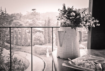 Still life with  Bouquet in  pitcher on wooden table against countryside の写真素材