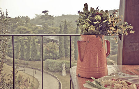 Still life with  Bouquet in  pitcher on wooden table against countryside background  Processed with vintage style の写真素材