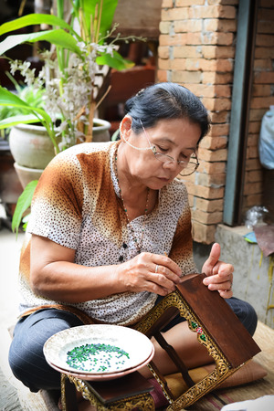 CHIANGMAI, THAILAND - JULY 28: An unidentified woman build altar table at Bann Tawai on July 28, 2014  in Chiang Mai,Thailand. Baan Tawai is the village of wood-carving handicrafts in Thailand.のeditorial素材
