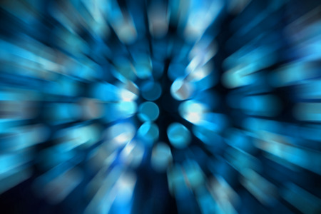 Abstract blue circular bokeh against dark background with zoom effect for use at graphic designの写真素材