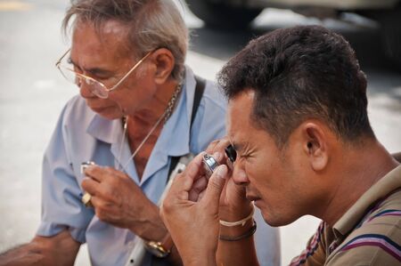 BANGKOK THAILAND-JUNE 19: Unidentified Thai Buddhism inspects on buddha amulets at amulet market on June 19, 2011 in Bangkok,Thailand.のeditorial素材