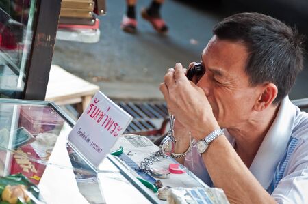 BANGKOK THAILAND-JUNE 19: Unidentified Thai Buddhism inspects on buddha amulets at amulet market on June 19, 2011 in Bangkok,Thailand.のeditorial素材