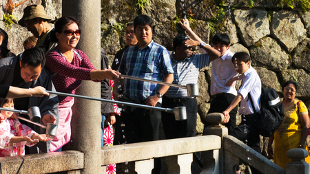 KYOTO, JAPAN - APRIL 28 : Tourist collecting water from the Otowa-no-taki waterfall ( for health, longevity, and success) at Kiyomizu temple on April 28, 2017 in Kyoto, Japanのeditorial素材