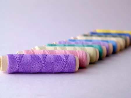 Colored sewing threads on light backgroundの写真素材