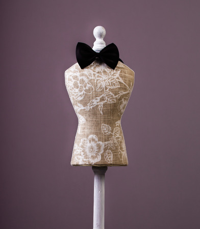 mannequin with bow-tie isolated on purple bacgroundの写真素材