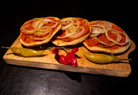 Homemade spicy hot ajvar sauce on  toasted bread with seared onions served on cutting boardの写真素材