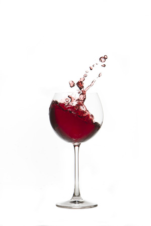 Red wine splash Glass with white backgroundの写真素材