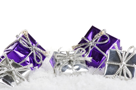 christmas presents purple and silver with artificial snow and white backgroundの写真素材