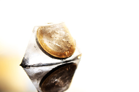 a 2 Euro coin in the ice cube without backgroundの写真素材