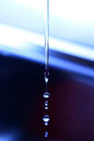 The fluid motion of water splashing as it is poured の写真素材