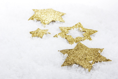 golden christmas stars on artificial snowの写真素材