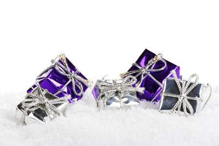 christmas presents purple and silver with artificial snow and white backgroundの写真素材