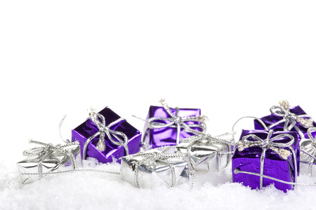 Presents purple and silver on artificial snow with white backgroundの写真素材