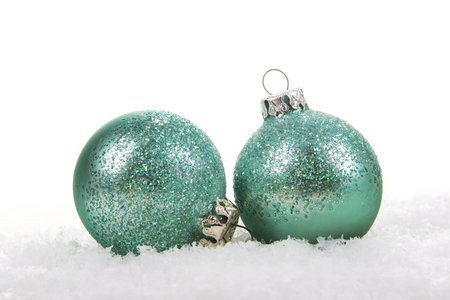 Christmas balls green, turquoise on artificial snow on white backgroundの写真素材