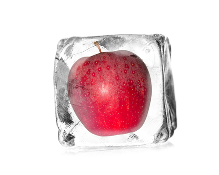 apple in a ice cube isolated with white backgroundの写真素材