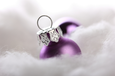 pink christmas balls on artificial snow with white backgroundの写真素材