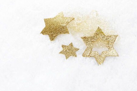 golden christmas stars on artificial snowの写真素材