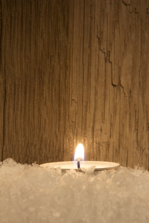 several candle in snow with wooden backgroundの写真素材