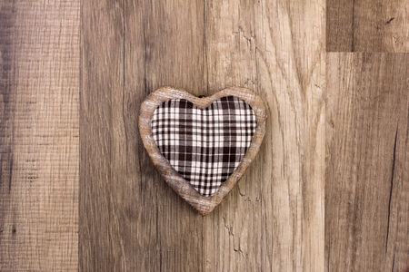 heart as symbol for christmas with wooden background の写真素材