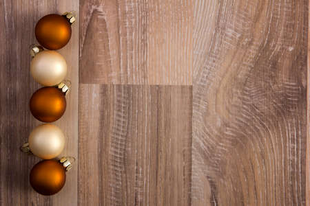 several christmas baubles bronze, brown, creme on wooden background の写真素材