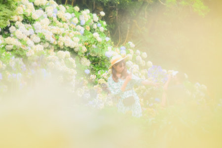 Beautiful asian woman wearing a hat and flower dress in the garden.