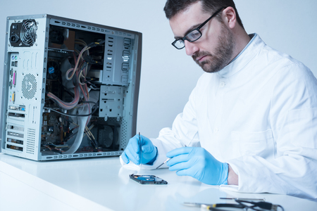 Lab engineer repairing and fixing broken hard disk for data recovery ...