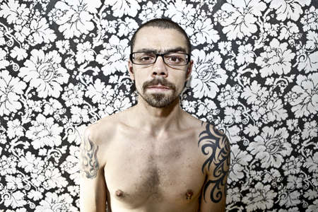 skinny tattoo guy on floral backgroundの写真素材