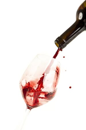 Red wine splash on a glass, white background.の写真素材