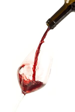 Red wine splash on a glass, white background.の写真素材