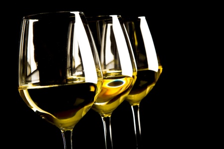 three glasses of white wine on black backgroundの写真素材
