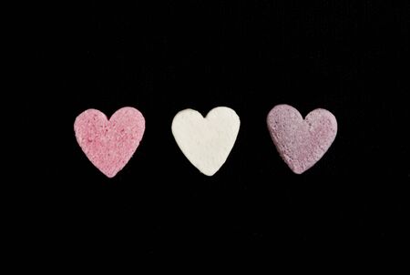heart shaped candy sweets on black bakgroundの写真素材