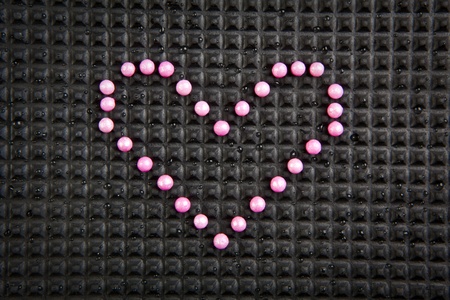 heart shape made with candy on rubber black backgroundの写真素材