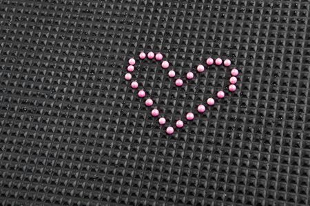 heart shape made with candy on rubber black backgroundの写真素材