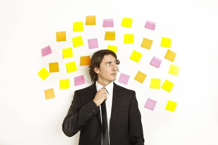 young businessman with postit reminder notes on the backgroundの写真素材