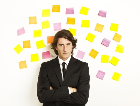 young businessman with postit reminder notes on the backgroundの写真素材