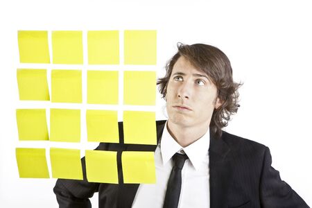 young businessman looking at postit reminder notesの写真素材