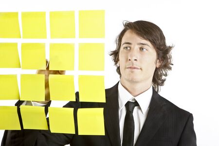 young businessman looking at postit reminder notesの写真素材
