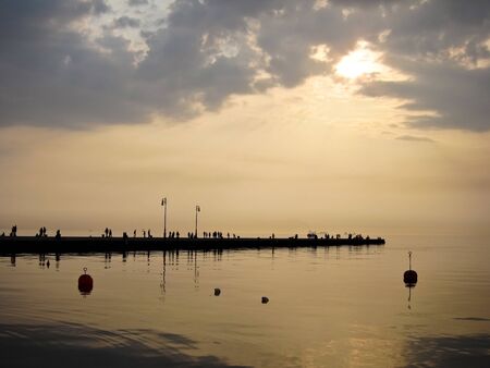 people on molo audace in trieste, peaceful sunset
