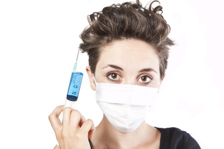Young pretty nurse in mask with syringeの写真素材