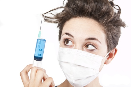 Young pretty nurse in mask with syringeの写真素材