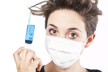 Young pretty nurse in mask with syringeの写真素材