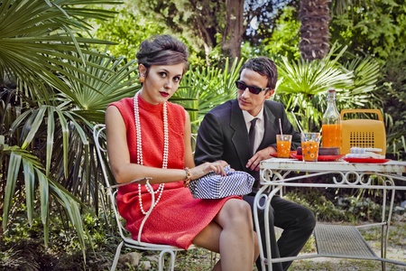 retro sixties style fashion couple having breakfast outdoorの写真素材